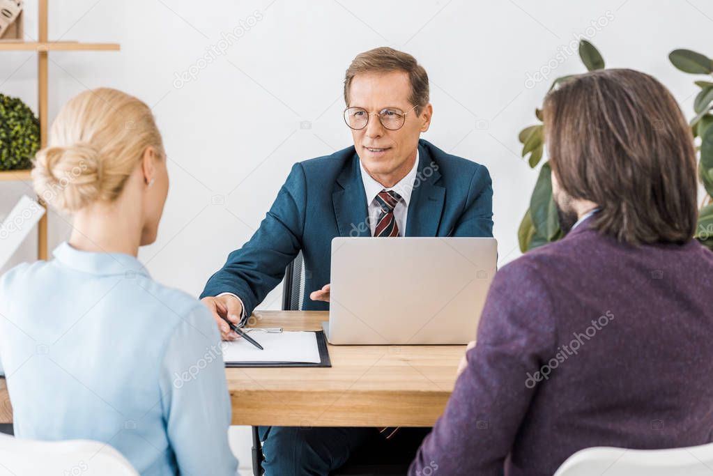 Consulente assicurativo che firma una polizza insieme ai clienti