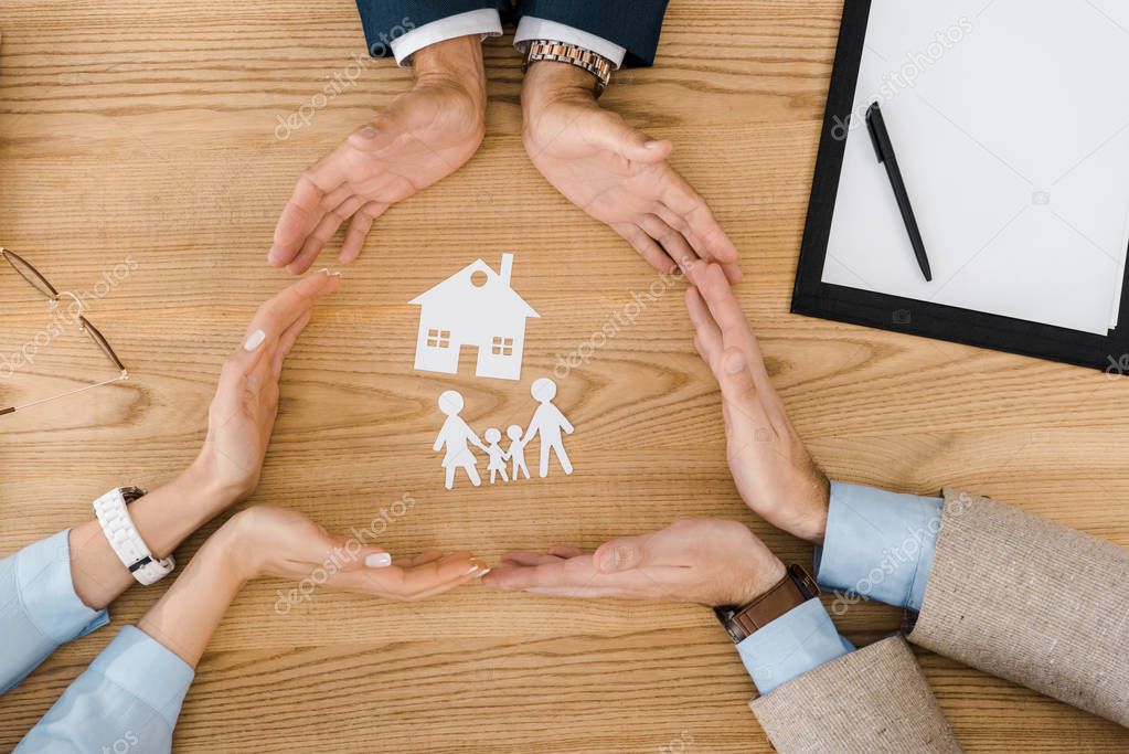 Consulente che illustra una polizza assicurativa a una famiglia seduta in ufficio